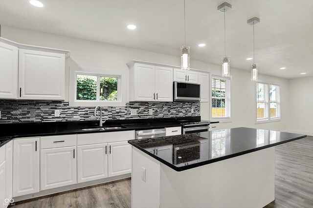 1923 N Parker Ave, Indianapolis, IN 46218 - kitchen with stainless steel appliances, light wood-type flooring, decorative backsplash, plenty of natural light, and recessed lighting