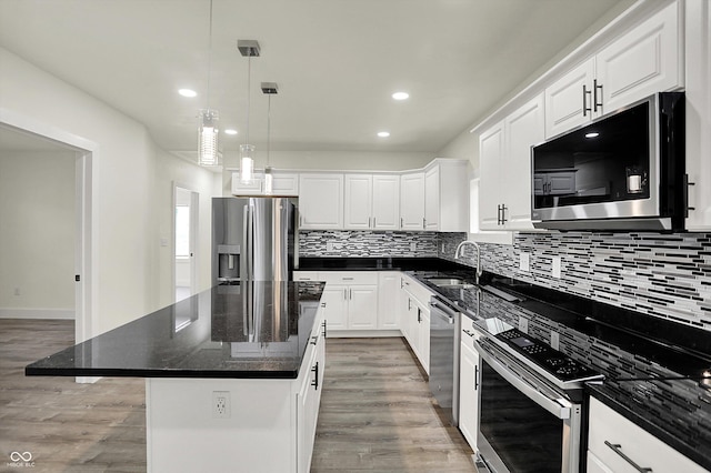 1923 N Parker Ave, Indianapolis, IN 46218 - kitchen featuring appliances with stainless steel finishes, light wood-style floors, tasteful backsplash, a kitchen island, and recessed lighting