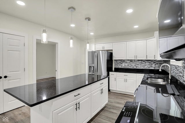 1923 N Parker Ave, Indianapolis, IN 46218 - kitchen featuring stainless steel fridge with ice dispenser, light wood-style floors, white cabinets, tasteful backsplash, and recessed lighting