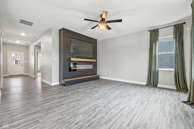 7225 Lockford S, Avon, IN 46123 - unfurnished living room featuring a fireplace, wood finished floors, and a ceiling fan