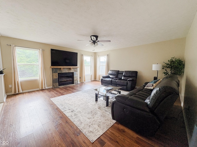 1381 Harrison Dr, Greenwood, IN 46143 - living area featuring plenty of natural light, ceiling fan, wood finished floors, and a tiled fireplace