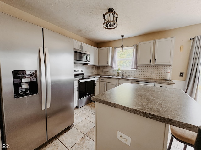 1381 Harrison Dr, Greenwood, IN 46143 - kitchen with stainless steel appliances, backsplash, dark countertops, hanging light fixtures, and light tile patterned floors