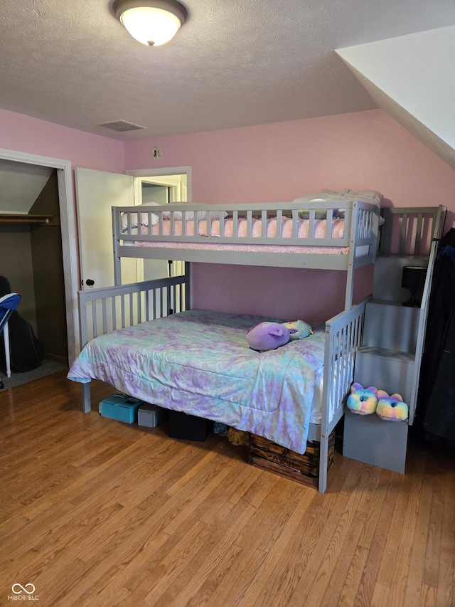 310 Tiffany Ln, North Vernon, IN 47265 - bedroom featuring wood finished floors, a textured ceiling, and a closet