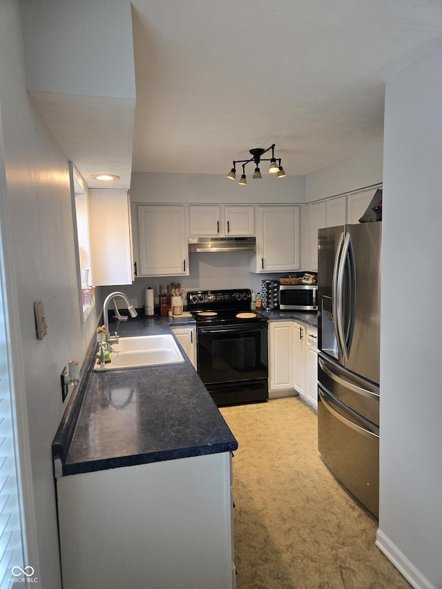 310 Tiffany Ln, North Vernon, IN 47265 - kitchen with appliances with stainless steel finishes, dark countertops, under cabinet range hood, white cabinets, and light carpet