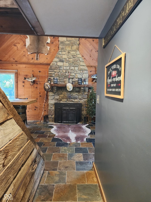 6774 S Becks Grove Rd, Freetown, IN 47235 - living room with wood walls, stone finish flooring, a fireplace, and beamed ceiling