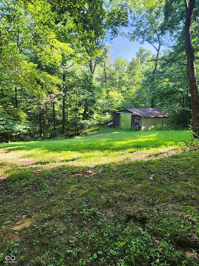 6774 S Becks Grove Rd, Freetown, IN 47235 - view of green lawn featuring an outbuilding, a view of trees, and a pole building