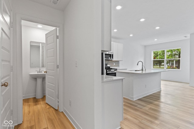 7265 Governors Row, Avon, IN 46123 - kitchen featuring stainless steel appliances, an island with sink, white cabinets, light wood-type flooring, and recessed lighting