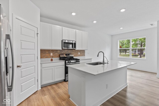 7265 Governors Row, Avon, IN 46123 - kitchen with stainless steel appliances, white cabinetry, decorative backsplash, light wood-style flooring, and light countertops