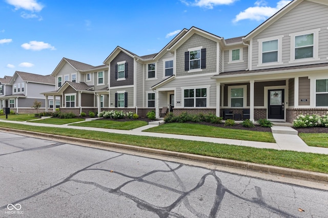 7265 Governors Row, Avon, IN 46123 - townhome / multi-family property with brick siding, a residential view, a front lawn, and covered porch