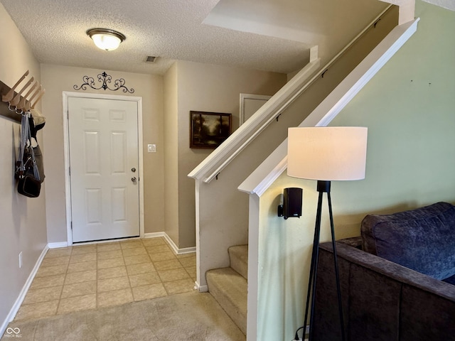 6309 Monteo Dr, Indianapolis, IN 46217 - entryway with stairway, a textured ceiling, and light tile patterned flooring