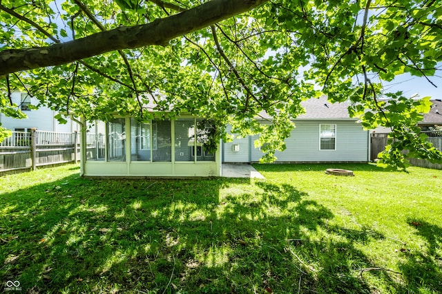 12956 Shandon Ln, Fishers, IN 46038 - back of house featuring a sunroom, a fenced backyard, a fire pit, and roof with shingles