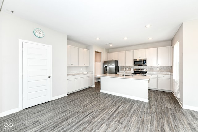 2234 S Bingham Pl, New Palestine, IN 46163 - kitchen featuring stainless steel appliances, wood finished floors, light countertops, a center island with sink, and recessed lighting