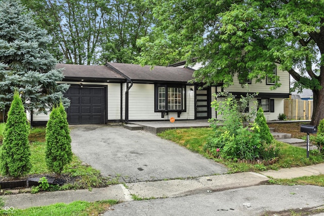 8041 Barry Rd, Indianapolis, IN 46219 - view of front of home with an attached garage, asphalt driveway, and roof with shingles