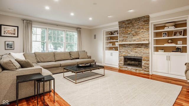 35 E 58th St, Indianapolis, IN 46220 - living area featuring wood finished floors, ornamental molding, built in shelves, a stone fireplace, and recessed lighting
