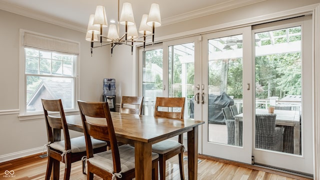 35 E 58th St, Indianapolis, IN 46220 - dining space featuring plenty of natural light, a chandelier, light wood finished floors, crown molding, and french doors