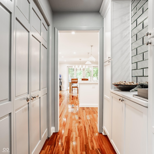 35 E 58th St, Indianapolis, IN 46220 - hall with light wood finished floors, a chandelier, and recessed lighting