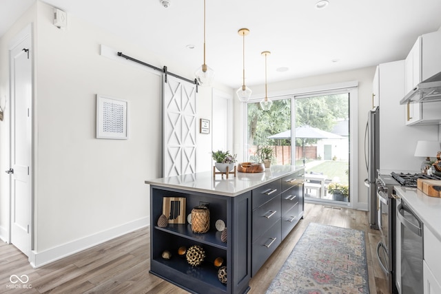 2539 Broadway St, Indianapolis, IN 46205 - kitchen with appliances with stainless steel finishes, a barn door, white cabinets, a center island, and light wood finished floors