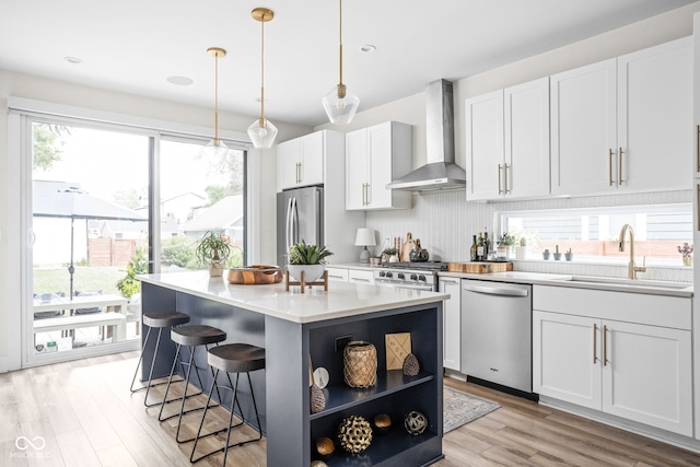 2539 Broadway St, Indianapolis, IN 46205 - kitchen with appliances with stainless steel finishes, wall chimney exhaust hood, open shelves, a kitchen island, and light wood-type flooring