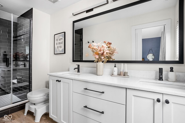 2539 Broadway St, Indianapolis, IN 46205 - bathroom featuring double vanity, a shower stall, and wood finished floors