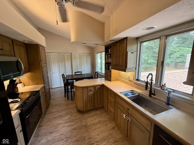 910 Ranch Rd, Connersville, IN 47331 - kitchen with stainless steel microwave, black range oven, a textured ceiling, plenty of natural light, and light countertops