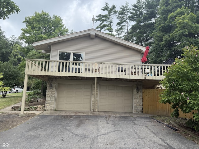 910 Ranch Rd, Connersville, IN 47331 - view of front of property with stone siding, a garage, driveway, and a balcony