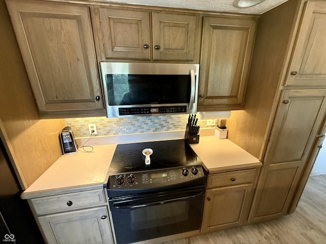 910 Ranch Rd, Connersville, IN 47331 - kitchen with stainless steel microwave, black electric range, light countertops, and backsplash