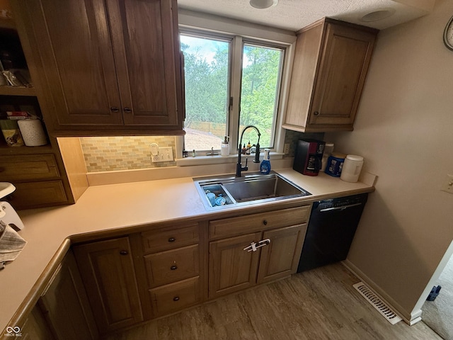 910 Ranch Rd, Connersville, IN 47331 - kitchen with black dishwasher, light countertops, wood finished floors, tasteful backsplash, and a textured ceiling