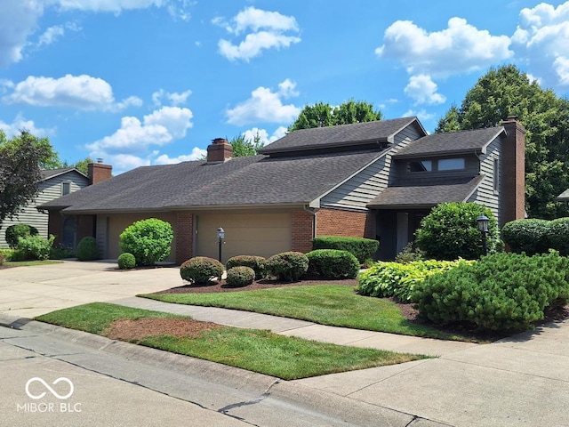5720 Bayside Dr, Fort Wayne, IN 46815 - traditional-style house featuring a garage, driveway, a chimney, brick siding, and roof with shingles