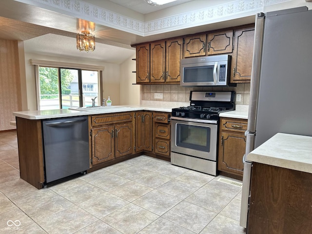 5720 Bayside Dr, Fort Wayne, IN 46815 - kitchen with stainless steel appliances, a peninsula, light tile patterned floors, decorative backsplash, and light countertops