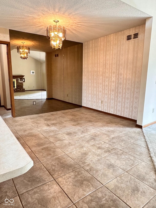 5720 Bayside Dr, Fort Wayne, IN 46815 - unfurnished dining area with a chandelier, tile patterned flooring, and a textured ceiling
