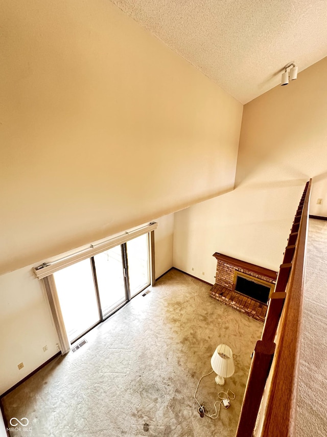 5720 Bayside Dr, Fort Wayne, IN 46815 - unfurnished living room featuring carpet flooring, a textured ceiling, and a brick fireplace