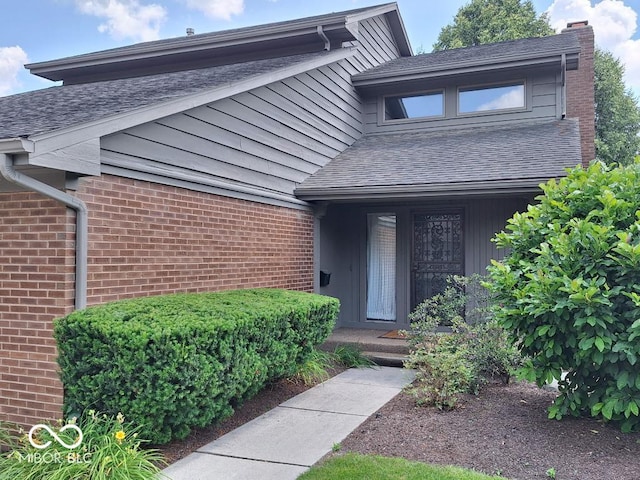 5720 Bayside Dr, Fort Wayne, IN 46815 - property entrance with brick siding, a chimney, and a shingled roof