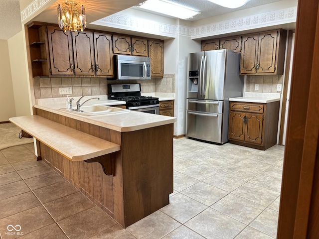 5720 Bayside Dr, Fort Wayne, IN 46815 - kitchen featuring appliances with stainless steel finishes, a peninsula, backsplash, light tile patterned floors, and a textured ceiling