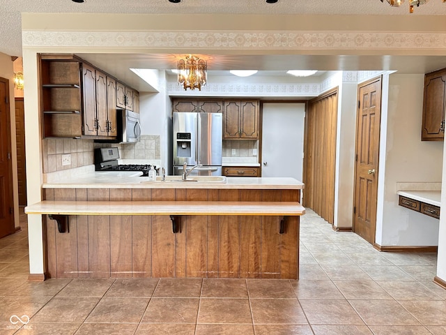 5720 Bayside Dr, Fort Wayne, IN 46815 - kitchen featuring stainless steel appliances, a peninsula, light countertops, and tasteful backsplash