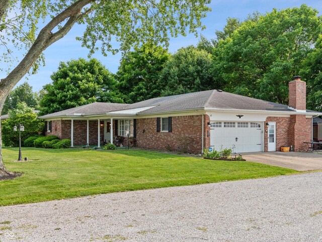 2601 N Everett St, Crawfordsville, IN 47933 - ranch-style home featuring a garage, brick siding, a chimney, and driveway