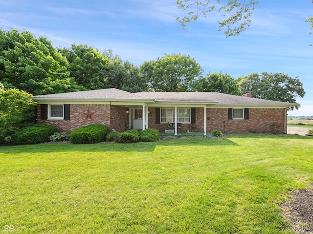 2601 N Everett St, Crawfordsville, IN 47933 - ranch-style house with a front yard, a chimney, covered porch, and brick siding