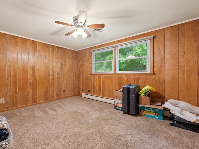 2601 N Everett St, Crawfordsville, IN 47933 - carpeted spare room with a baseboard heating unit, wooden walls, and a ceiling fan