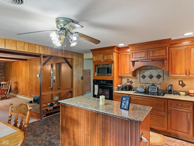 2601 N Everett St, Crawfordsville, IN 47933 - kitchen with black appliances, a ceiling fan, a kitchen island, decorative backsplash, and light stone counters