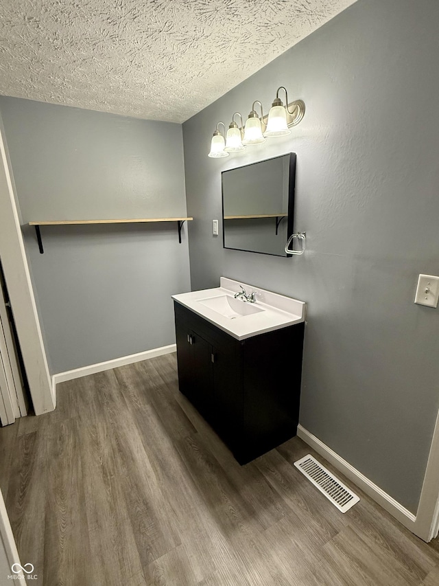 4833 Pennsylvania St, Clayton, IN 46118 - bathroom featuring wood finished floors, vanity, and a textured ceiling