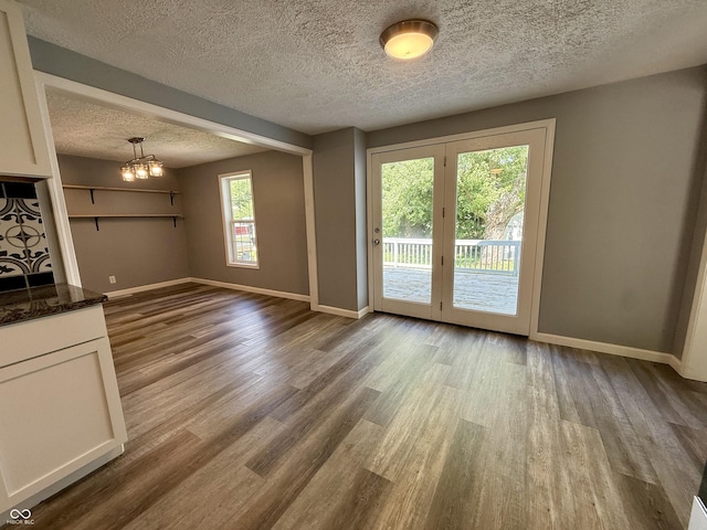 4833 Pennsylvania St, Clayton, IN 46118 - unfurnished living room featuring a textured ceiling, wood finished floors, and a chandelier