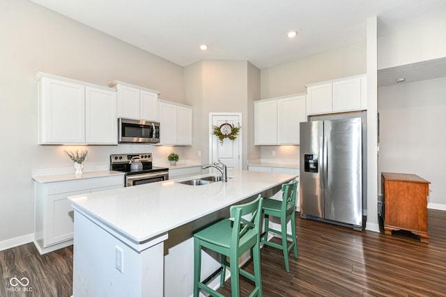 9846 Zion Way, Pendleton, IN 46064 - kitchen featuring appliances with stainless steel finishes, dark wood-style flooring, a center island with sink, light countertops, and white cabinetry