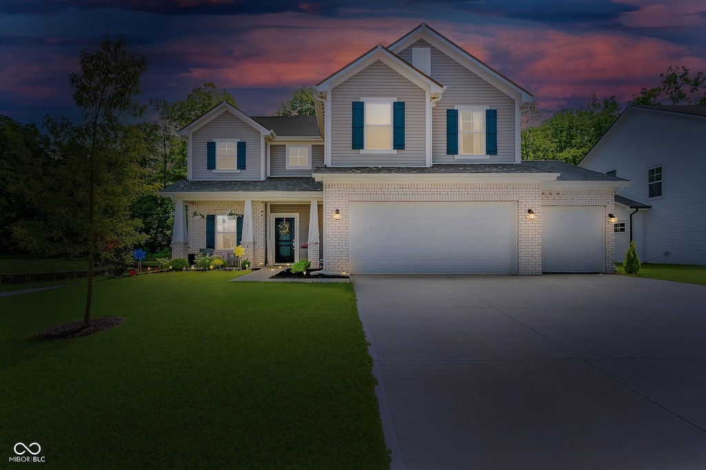 17977 Ambrosia Trl, Westfield, IN 46074 - view of front of property with concrete driveway, a garage, a front lawn, brick siding, and a shingled roof