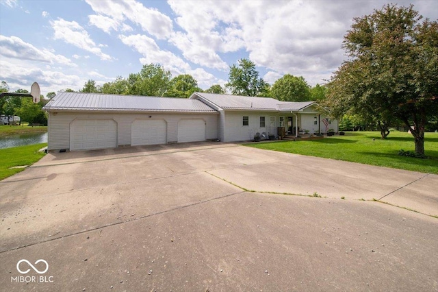 11815 E Pocahontas Dr, Greencastle, IN 46135 - ranch-style house with a front yard, a garage, concrete driveway, a metal roof, and a water view