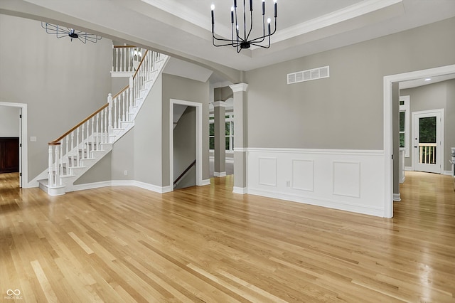 7131 Nile Ridge Ct, Indianapolis, IN 46236 - unfurnished dining area with light wood-style floors, stairway, a chandelier, ornamental molding, and ornate columns