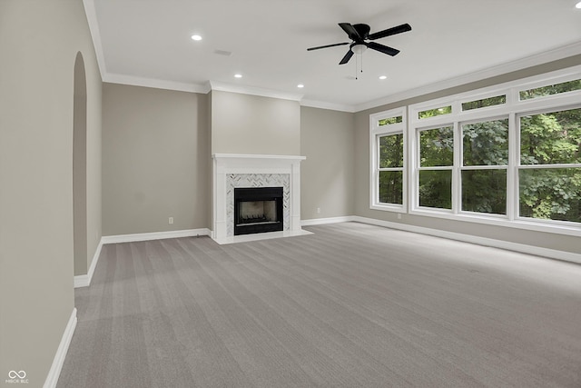 7131 Nile Ridge Ct, Indianapolis, IN 46236 - unfurnished living room with crown molding, a tiled fireplace, light carpet, ceiling fan, and arched walkways