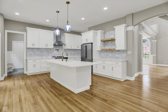 7131 Nile Ridge Ct, Indianapolis, IN 46236 - kitchen featuring high quality fridge, open shelves, light countertops, arched walkways, and light wood-type flooring