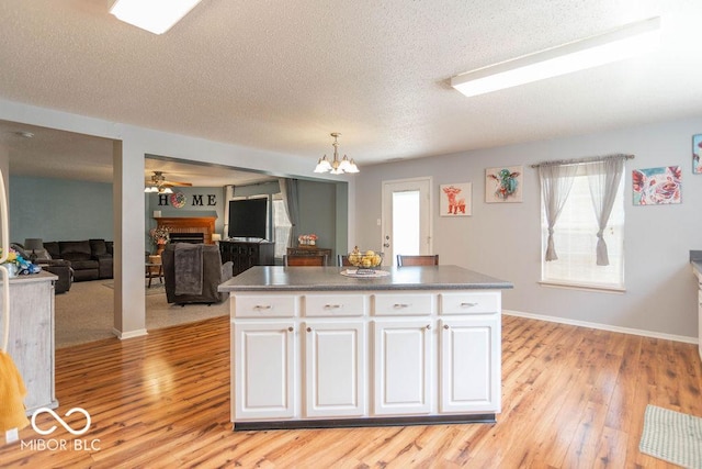 8703 Mellot Way, Camby, IN 46113 - kitchen featuring light wood-type flooring, white cabinets, a fireplace, ceiling fan, and a kitchen island