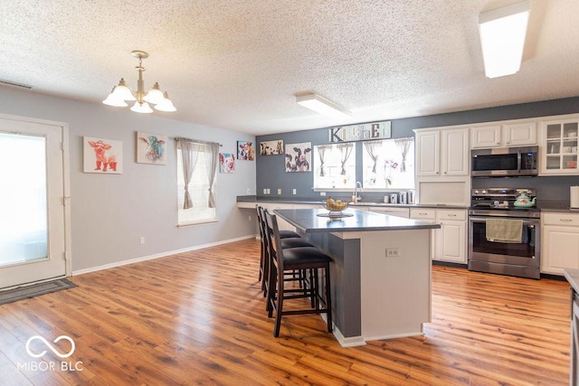 8703 Mellot Way, Camby, IN 46113 - kitchen featuring appliances with stainless steel finishes, plenty of natural light, white cabinetry, and a textured ceiling