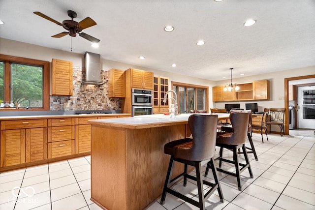 5298 Royal Troon Way, Avon, IN 46123 - kitchen featuring wall chimney exhaust hood, stainless steel double oven, light countertops, recessed lighting, and a breakfast bar area