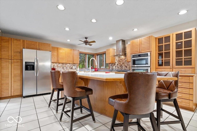 5298 Royal Troon Way, Avon, IN 46123 - kitchen featuring appliances with stainless steel finishes, wall chimney range hood, light countertops, backsplash, and ceiling fan